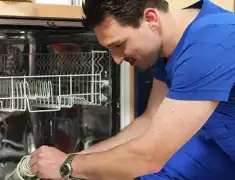 Dishwasher repair technician inspecting and servicing an open dishwasher in Oakland, CA