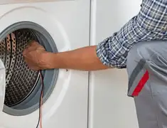 Dryer repair technician diagnosing and servicing a clothes dryer in Oakland, CA