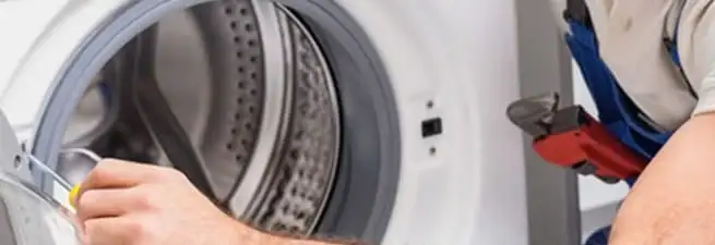 Appliance technician repairing a clothes dryer drum and internal parts in Oakland, CA