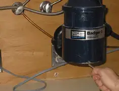 Garbage disposal repair technician tightening the mounting ring under a sink in Oakland, CA