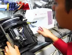 Vacuum repair technician servicing internal components on a workbench in Oakland, CA