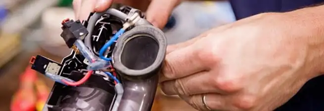 Vacuum repair technician reconnecting wiring and components in Oakland, CA