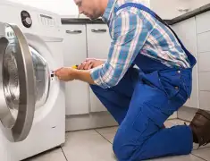 Washing machine repair technician servicing a front-load washer in Oakland, CA
