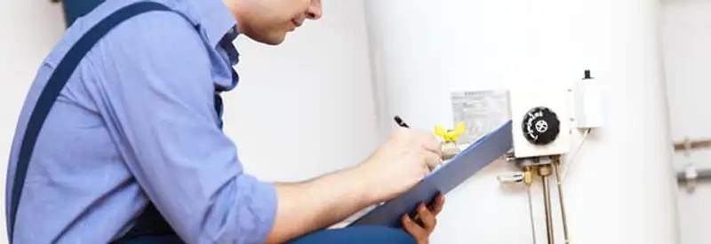 Water heater repair technician inspecting the unit and recording service notes in Oakland, CA